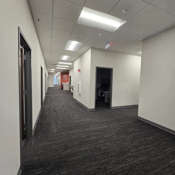 A commercial building in Cary, NC, with an interior corridor showcasing freshly painted off-white walls. 