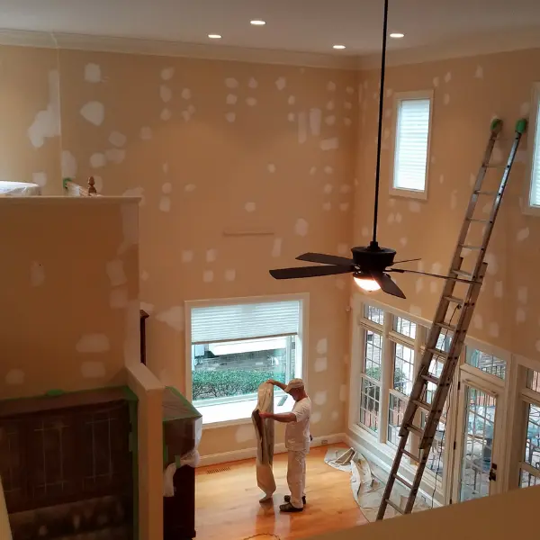 Drywall seam and nail pop repairs in a two-story living room in Wake Forest, NC.