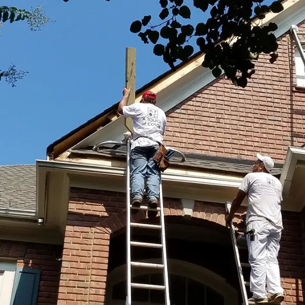 Carpenters replacing the exterior fascia board high up on a home in Raleigh, NC.