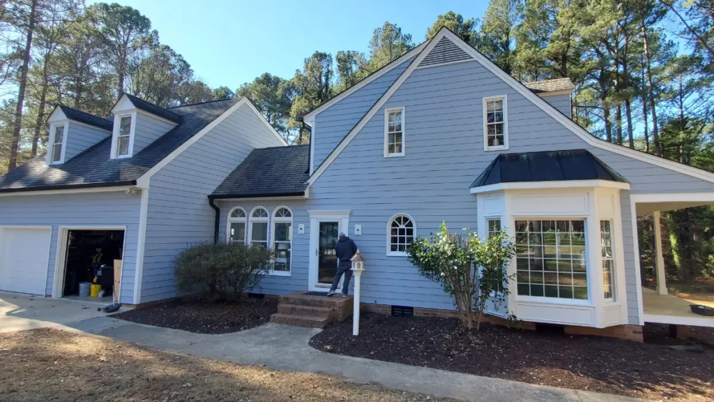 Left side of a large light gray house after painting and yard clean up by ATOC in Raleigh.