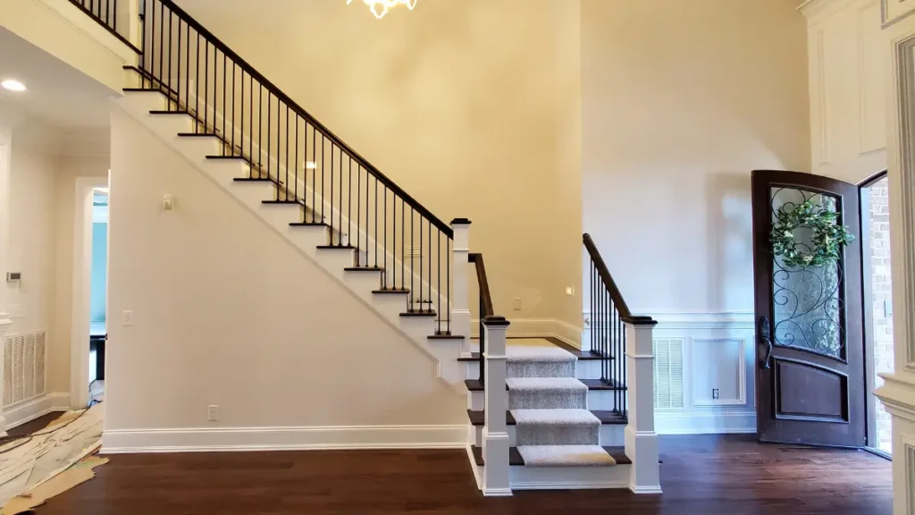 Interior painted staircase in a foyer with contrasting wood rails and stair treads in Apex, NC by A Touch of Color.