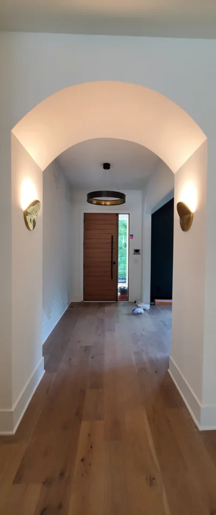 The foyer entrance of a home with the lights on to showcase perfectly painted walls by A Touch of Color Painting.