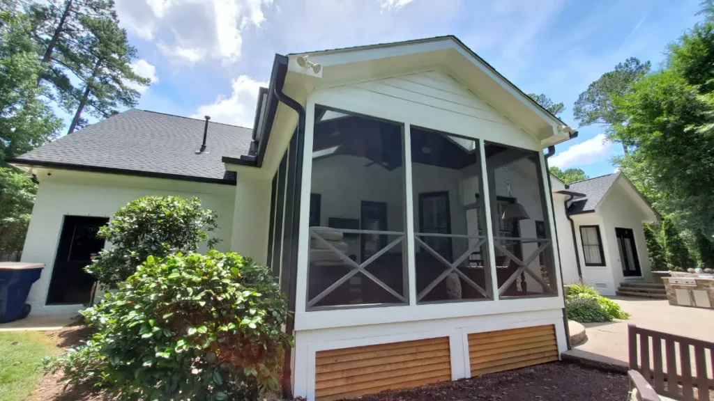 Rear completed porch build and painting with modern handrails and a stained wood deck skirt.