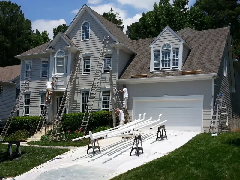  A Touch of Color painters performing expert exterior painting and prep work on a residential home in Raleigh, NC, front yard.