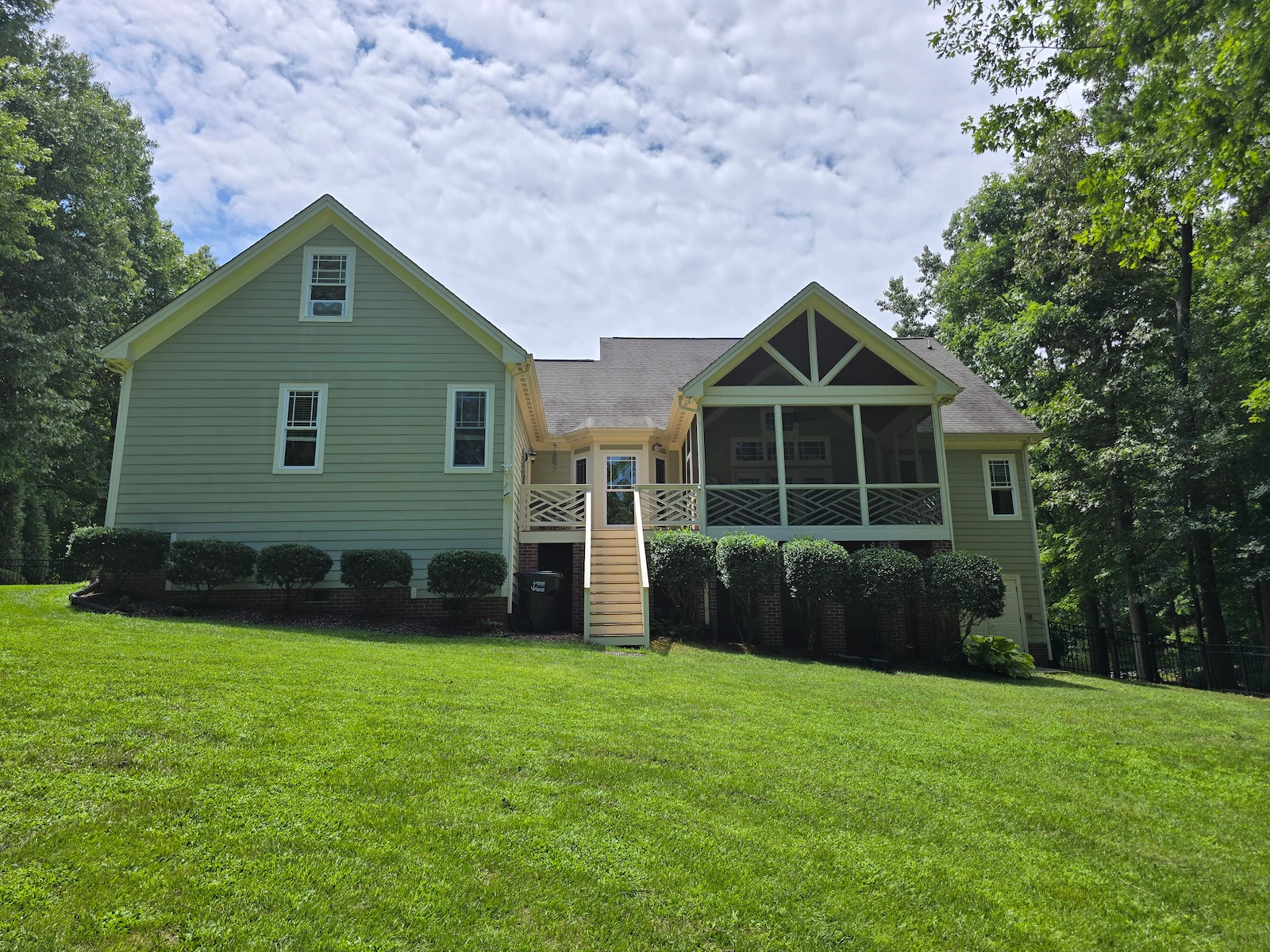 Outdoor rear image of a home renovation including a porch, siding, exterior trim and final paint coats.