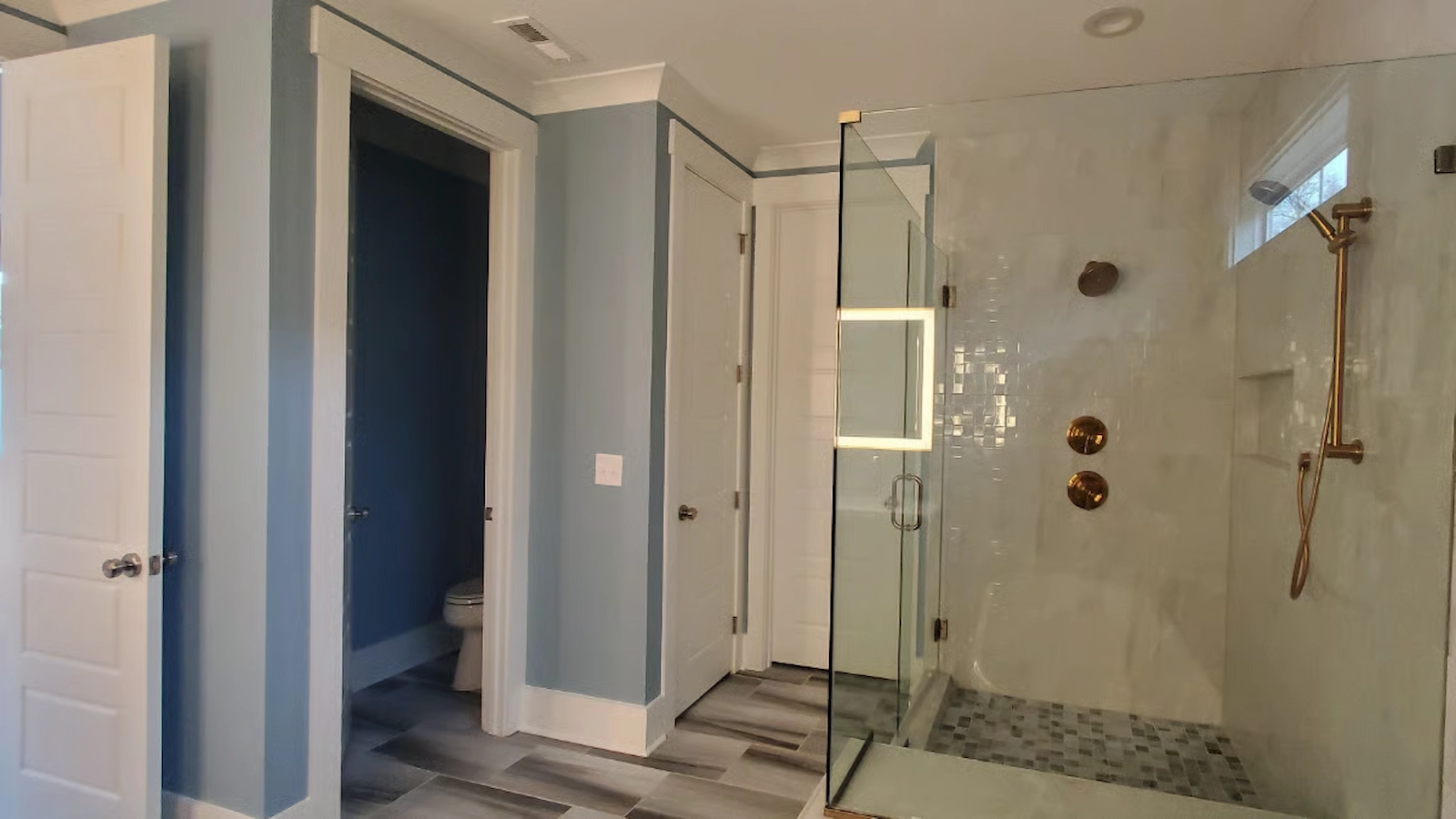 Blue painted bathroom walls inside a home in by A Touch of Color Painting.