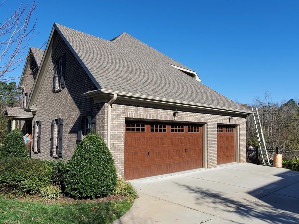 Brick home trim painted by A Touch of Color Painting & General Contracting. Showcases detailed trim work on a repeat clients homes in Apex, NC.